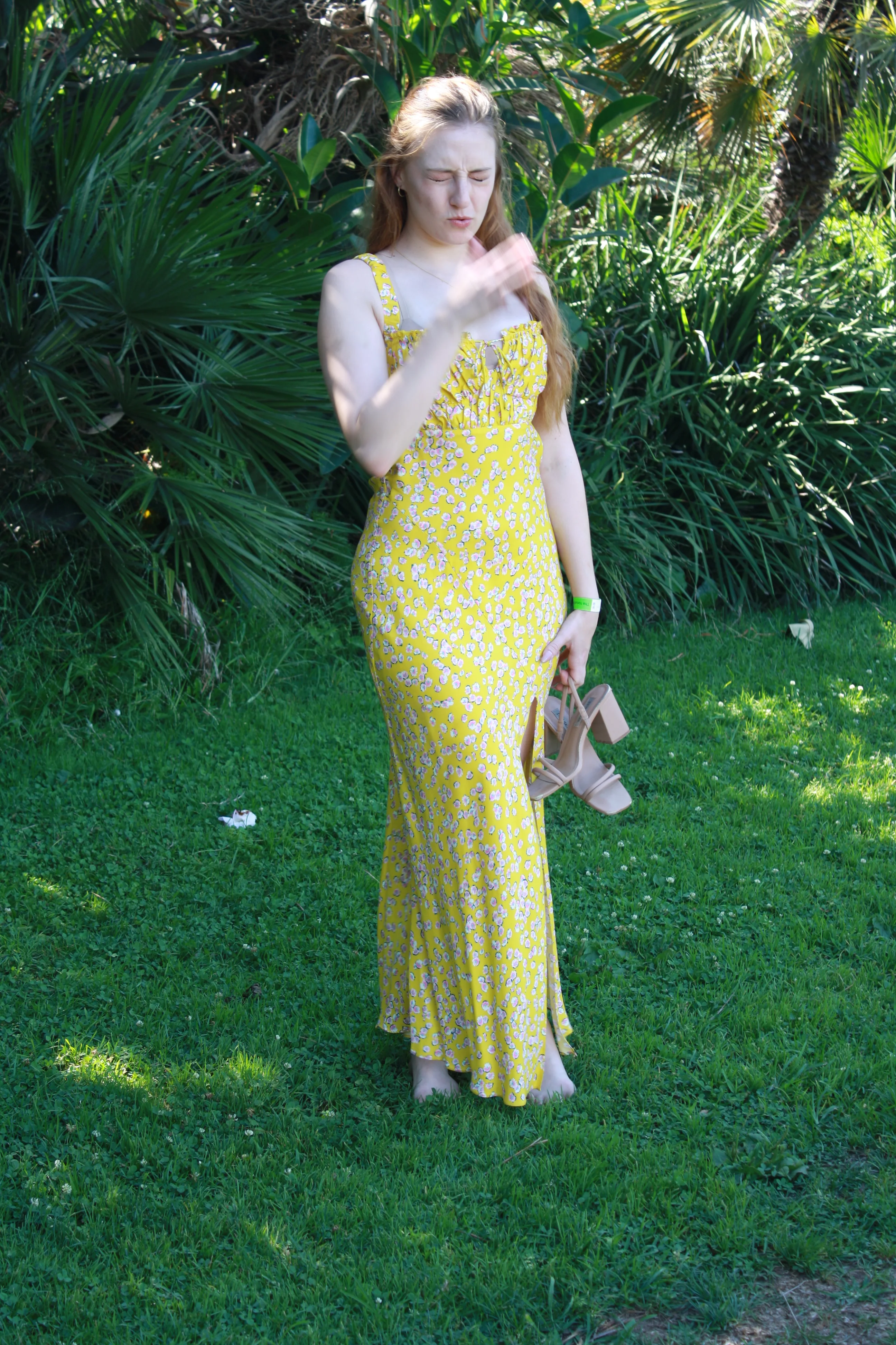 Jordie Morris standing on the lawn with one hand near her chin at the Exposition Park Rose Garden.